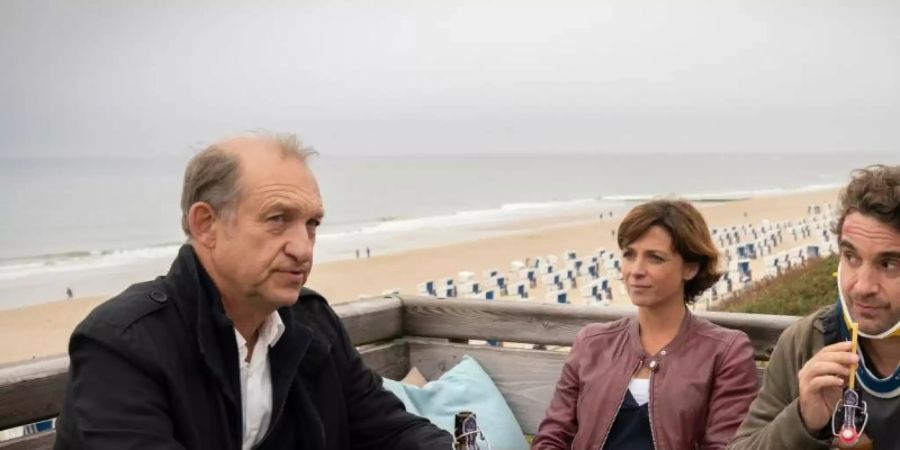 Feierabendbier im Strandrestaurant für Carl Sievers (Peter Heinrich Brix, l), Ina Behrendsen (Julia Brendler) und Hinnerk Feldmann (Oliver Wnuk). Foto: Georges Pauly/ZDF/dpa