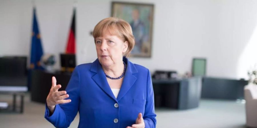 Angela Merkel gibt zwei Gemälde des Malers Emil Nolde aus ihrem Amtszimmer zurück. Foto: Kay Nietfeld