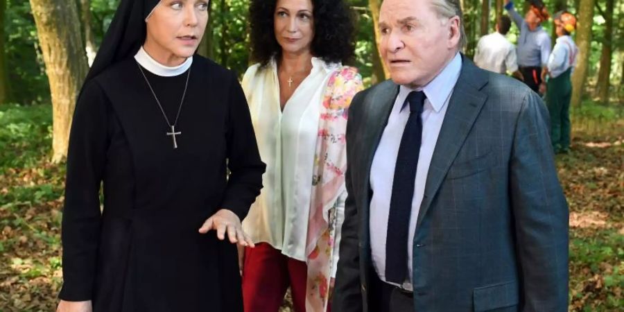 Schwester Hanna (Janina Hartwig) erwischt Jenny Winter (Barbara Wussow) und Bürgermeister Wöller (Fritz Wepper) bei Vermessungsarbeiten im Wald. Foto: ARD/Barbara Bauriedl