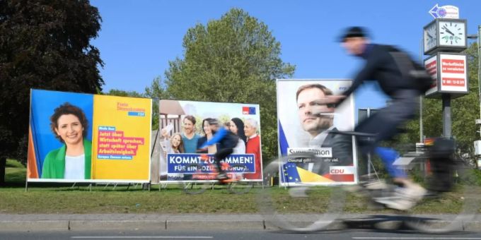 Radfahrer fährt an Wahlplakaten vorbei Radfahrer fährt an Wahlplakaten vorbei