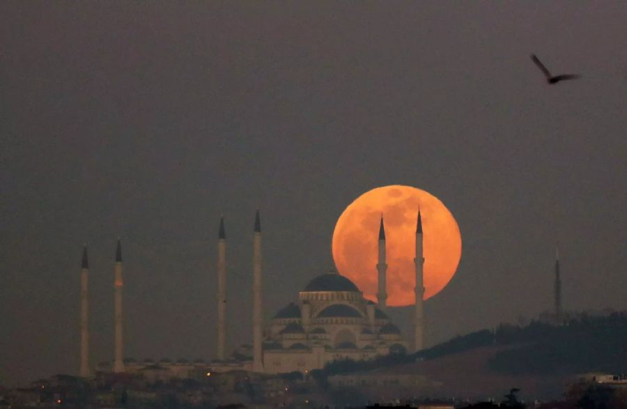 Der Supermond erhebt sich hinter der Camlica Moschee in Istanbul, Türkei.