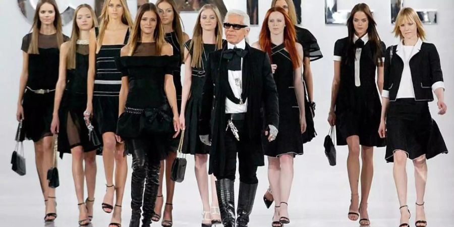 Karl Lagerfeld geht mit seinen Models am Ende der Präsentation der Wintermode 2005/06 über den Laufsteg. Foto: Olivier Hoslet/epa