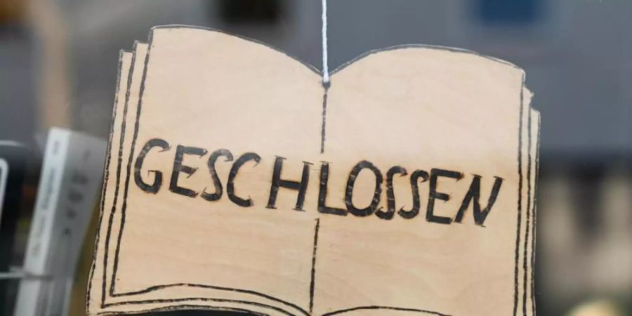 Ein «Geschlossen»-Schild vor einer Buchhandlung. Foto: Uwe Zucchi/dpa