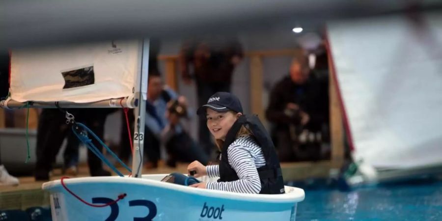 Eines der etwas kleineren Modelle: Model Mia in einem «Optimist» bei der Wassersportmesse «Boot 2020». Foto: Federico Gambarini/dpa