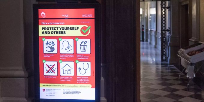 Die Hinweise in Englisch des Bundesamtes für Gesundheit auf die Verhaltenregeln im Hinblick auf die Krise des neuen Coronavirus werden zusammen mit dem Livebild von Bundesrat Ueli Maurer.