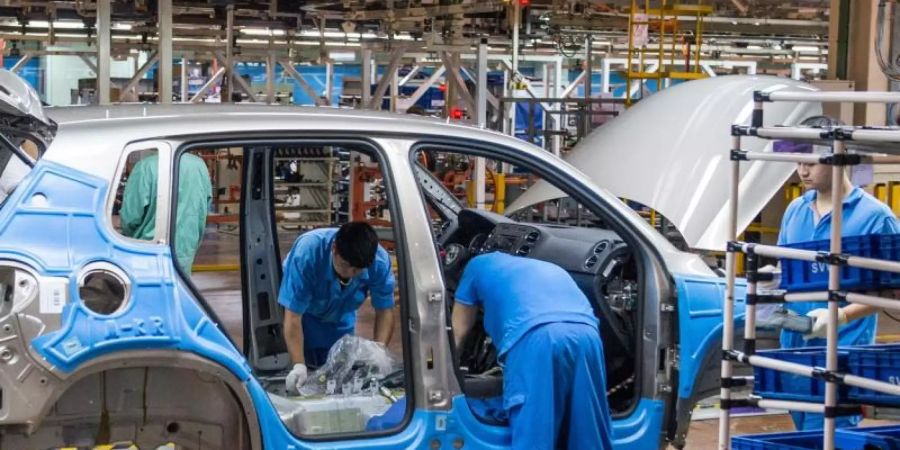 Mitarbeiter montieren im Werk der Volkswagen AG in Anting bei Shanghai einen VW Tiguan. Foto: Ole Spata/dpa