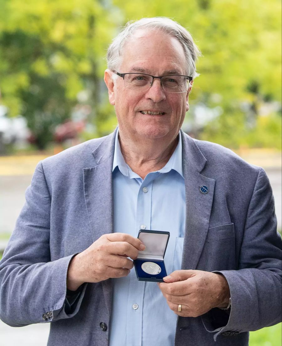 Der Chemiker Stanley Whittingham hält eine Medaille zum Gedenken an den Physiker Einstein in der Hand.