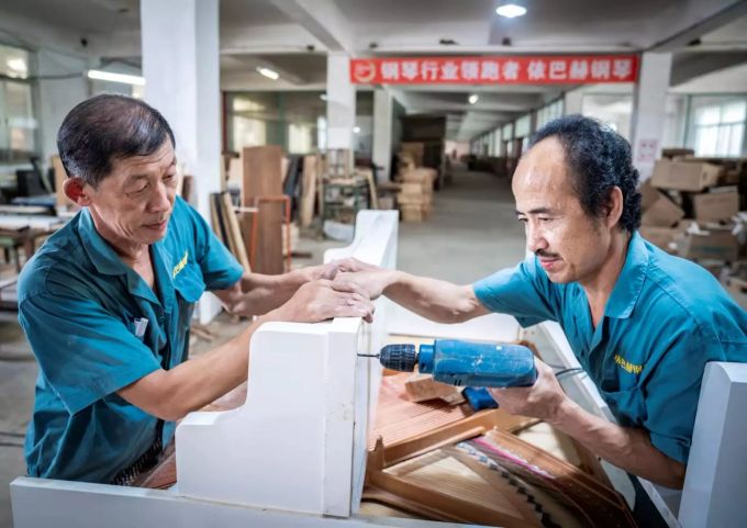 Klaviertechniker montieren das Gehäuse eines Klaviers. Der Handelskrieg mit den USA erschwert es China, seine ursprünglichen Wachstumsziele einzuhalten. Handelskrieg zwischen USA und China