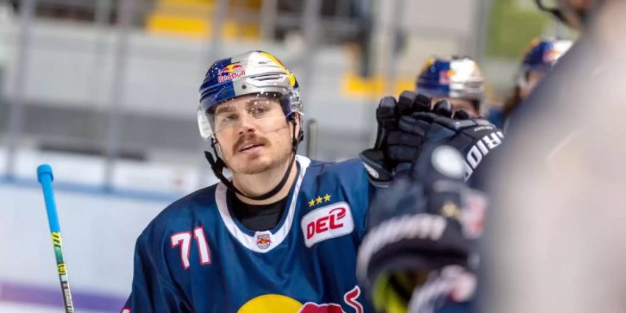 Chris Bourque von Red Bull München klatscht nach seinem 1:0 gegen die Straubing Tigers seine Teamkollegen ab. Foto: Lino Mirgeler/dpa