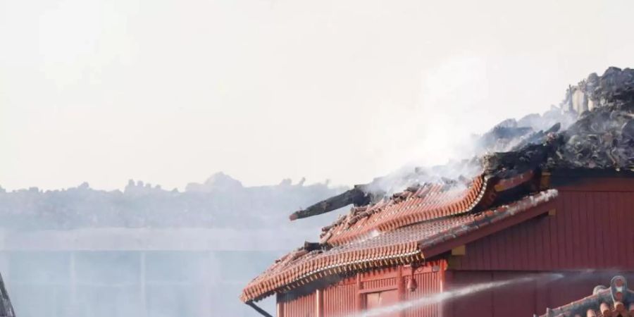 Feuerwehrleute versuchen einen Brand der historischen Shuri Burg zu löschen. Foto: Jun Hirata/Kyodo News/AP/dpa
