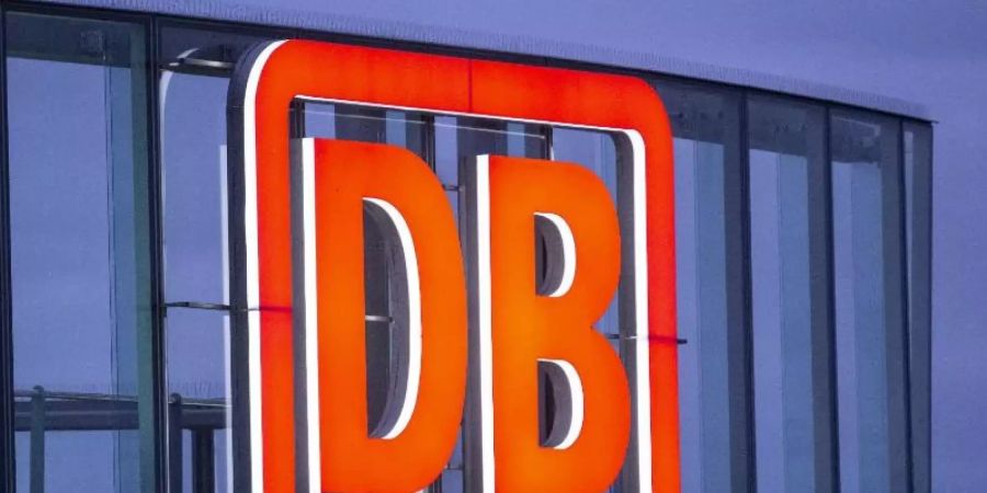 Das Logo der Deutschen Bahn AG ist in der Abenddämmerung am Bahntower am Potsdamer Platz zu sehen. Foto: Christoph Soeder