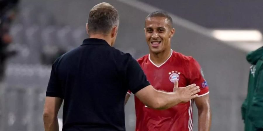 Münchens Trainer Hansi Flick spricht am Spielfeldrand mit Thiago (r). Foto: Sven Hoppe/dpa
