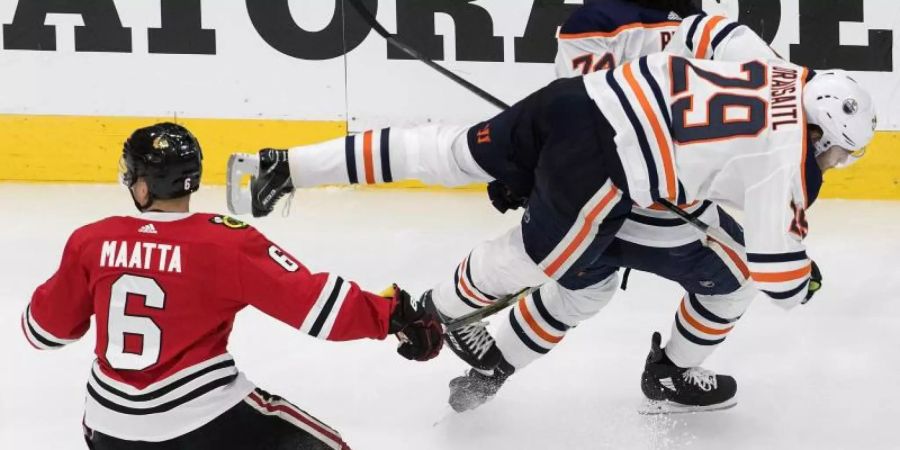 Edmontons Leon Draisaitl (r) wird durch Olli Maatta von den Chicago Blackhawks zu Fall gebracht. Foto: Jason Franson/The Canadian Press/AP/dpa