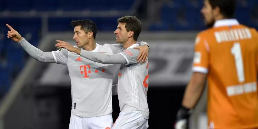 Bayerns Robert Lewandowski (l) und Thomas Müller bejubeln Müller's Tor zur Führung. Foto: Martin Meissner/AP-Pool/dpa