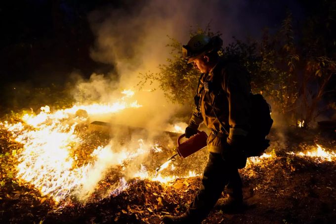 Ein Feuerwehrmann löscht den Waldbrand. waldbrand
