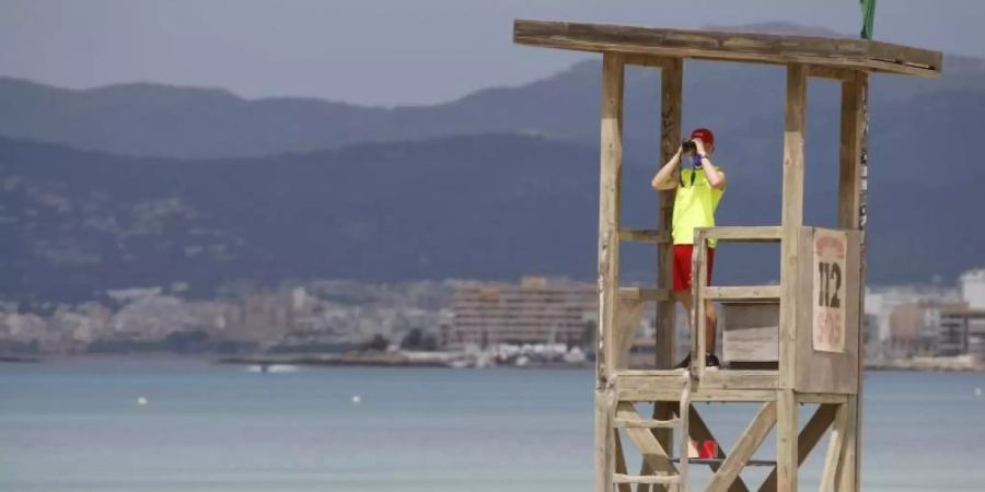 Ein Rettungsschwimmer beobachtet den Strand von El Arenal auf Mallorca. Foto: Clara Margais/dpa