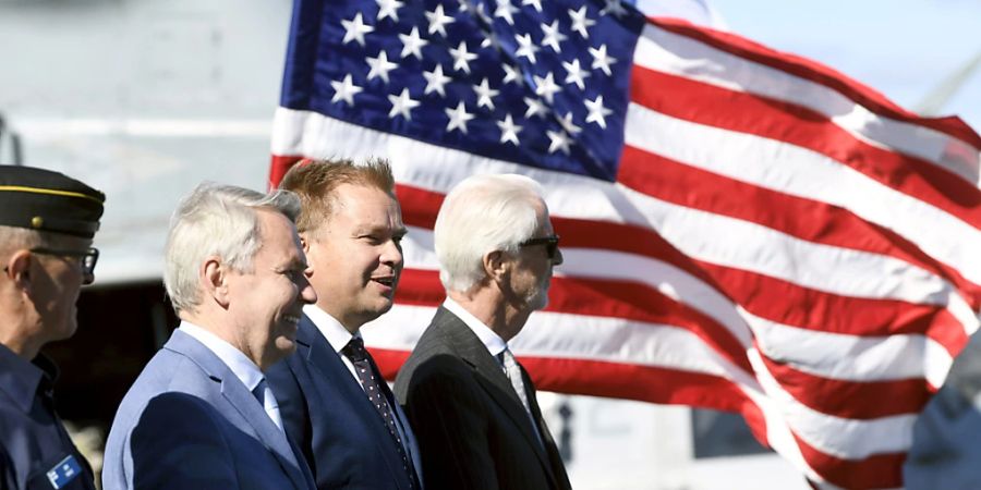 Pekka Haavisto (2.v.l), Aussenminister von Finnland, Antti Kaikkonen, Vederrteidigungsminister von Finnland, und Douglas T. Hickey, Botschafter der USA in Finnland, besuchen die Medien auf dem Deck des amphibischen Angriffsschiffs USS Kearsarge der Wasp-Klasse im Hafen von Hernesaari in Helsinki. Foto: Antti Aimo-Koivisto/Lehtikuva/dpa - ACHTUNG: Nur zur redaktionellen Verwendung und nur mit vollständiger Nennung des vorstehenden Credits