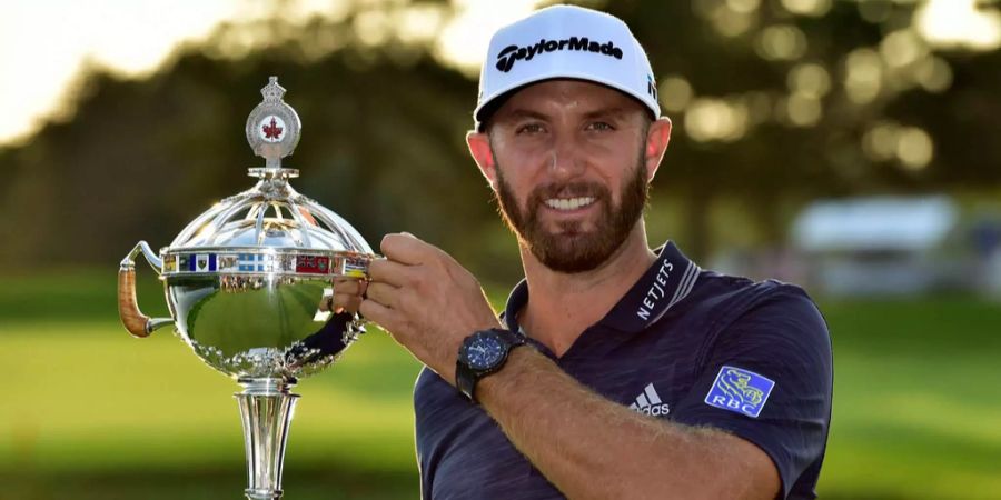 Dustin Johnson aus den USA zeigt nach den gewonnen Canadian Open die Trophäe.