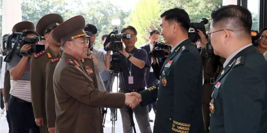 Kim Do-gyun aus Südkorea (rechts) und An Ik-san aus Nordkorea (links) begrüssen sich zu den Gesprächen.