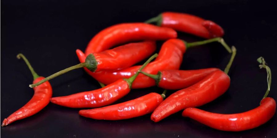 Scharfes Essen – zum Beispiel gewürzt mit Chilis – hilft beim Schwitzen.