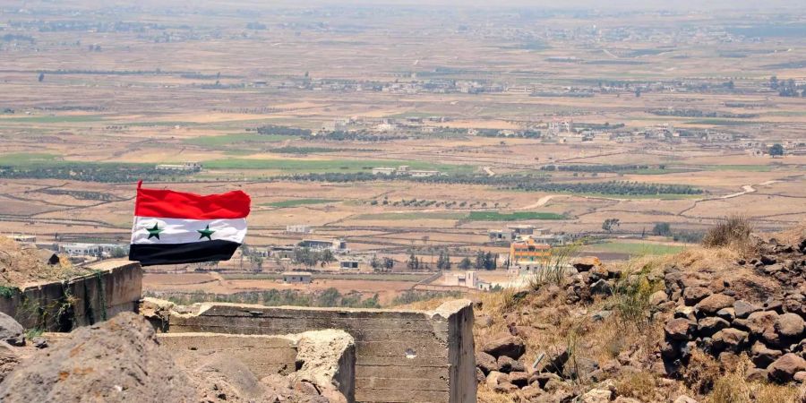 Eine syrische Nationalflagge weht auf einer Anhöhe des Bergs von Al Jabiyeh, einer strategisch wichtigen Position, die kürzlich von der syrischen Armee zurückerobert wurde.