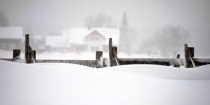 Ein Schneefangzaun steht im tiefen Schnee. (Symbolbild) Schneefangzaun