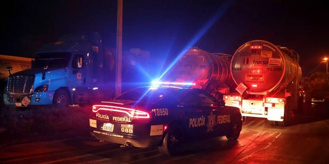 Ein Polizeiauto eskortiert ein Tanklastwagen.