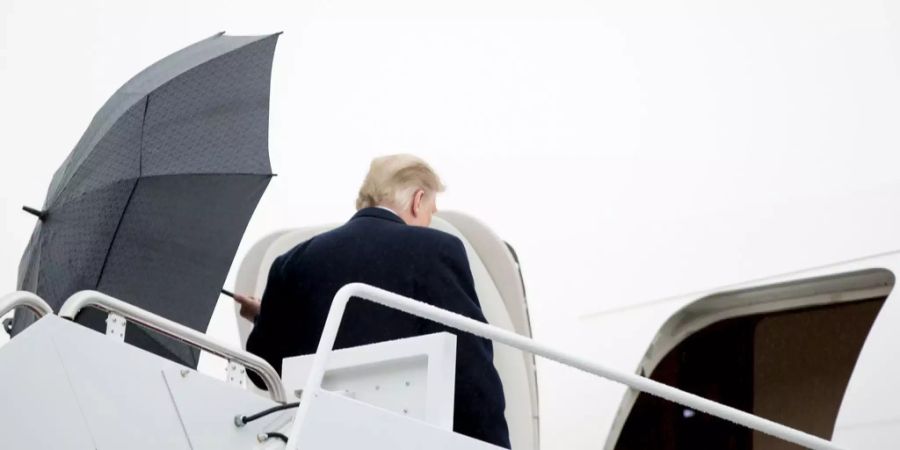 Donald Trump mit dem Schirm in der Hand vor der Air Force One.