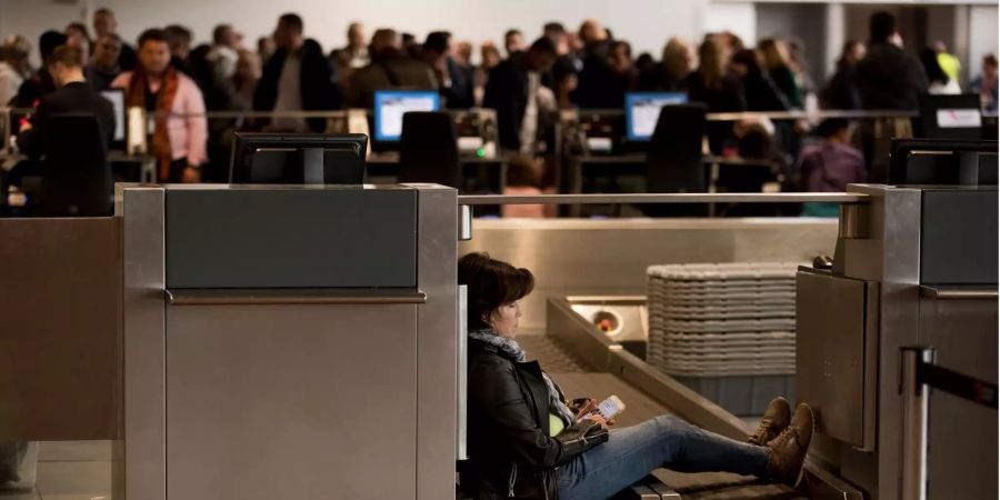 Eine Frau sitzt während eines Streiks am Flughafen Brüssel-Zaventem an einem Check-in-Schalter.