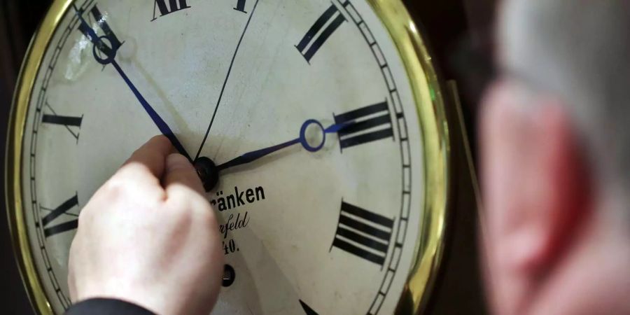 Ein Uhrenhändler in Wuppertal (D) stellt eine Uhr von zwei auf drei Uhr vor.