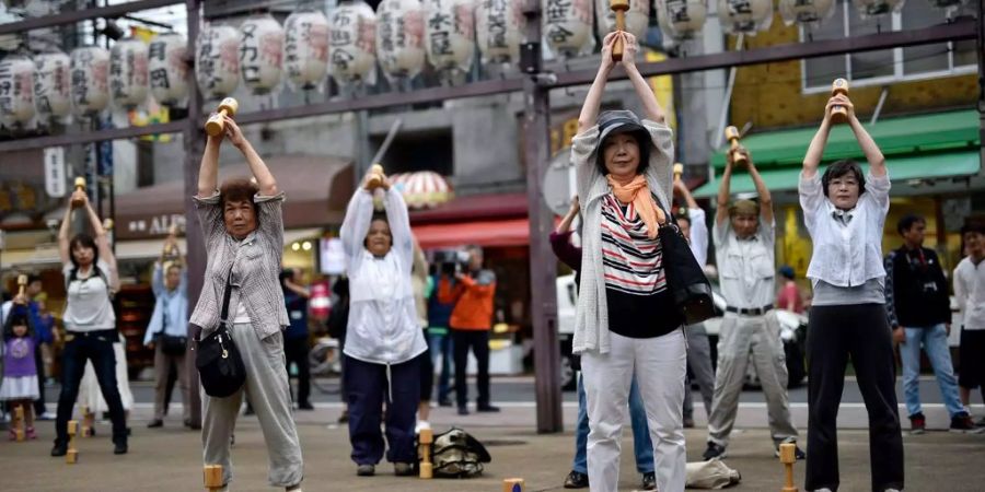 Ältere Menschen trainieren in der Öffentlichkeit an einem Event während des «Respect»-Tages in Tokio.