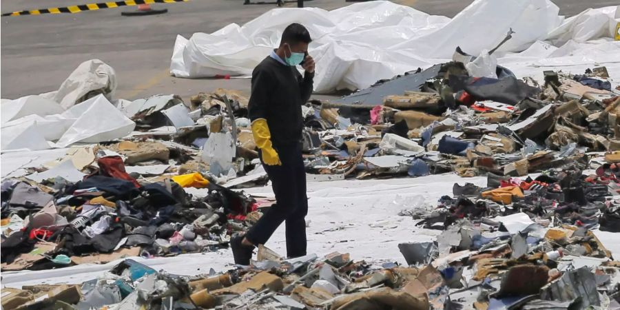 Ein Ermittler geht inmitten von Trümmern des abgestürzten Passagierflugzeugs der Fluggesellschaft Lion Air.