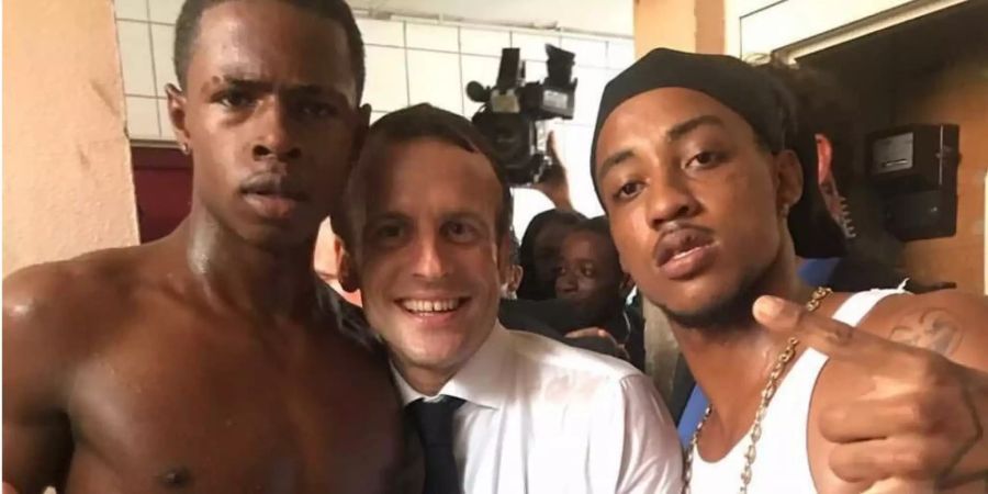 Frankreichs Präsident Emmanuel Macron posiert mit den zwei jungen Männern.