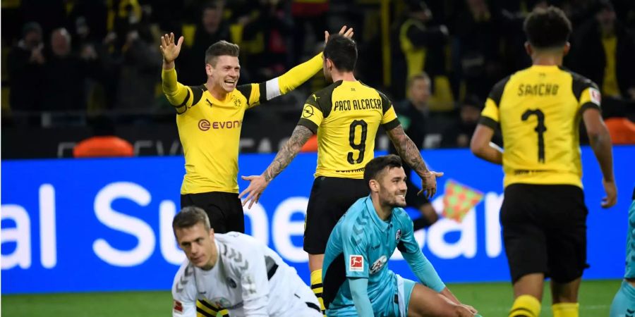 Lukasz Piszczek (links) und Paco Alcacer (Mitte) von Dortmund bejubeln das 2:0 Tor gegen Freiburg.