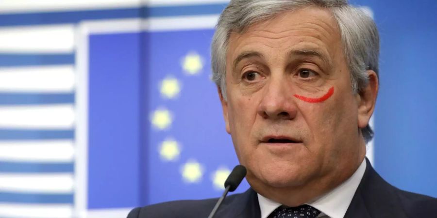 Der EU-Parlamentspräsident Antonio Tajani hält einer Medienkonferenz in Brüssel mit einem geschminkten, roten Balken unter dem Auge.