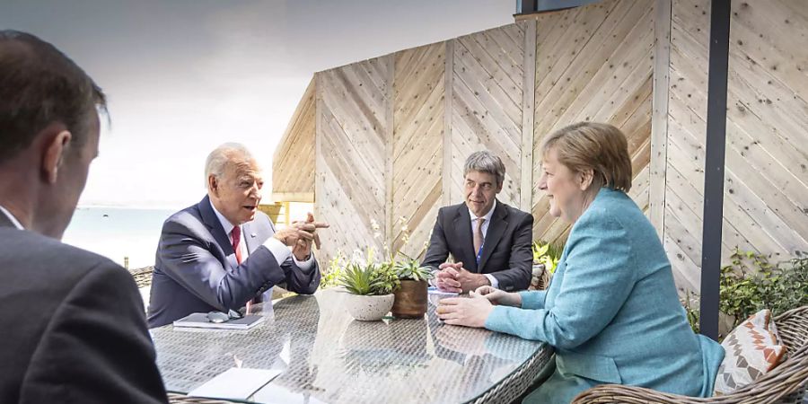 HANDOUT - Bundeskanzlerin Angela Merkel (CDU) und US-Präsident Joe Biden (2.v.l.) sitzen zu Beginn ihres Gesprächs am Rande des G7-Gipfels mit ihren aussenpolitischen Beratern Jan Hecker (2.v.r.) und Jake Sullivan (l) zusammen. Foto: Guido Bergmann/Bundesregierung/dpa