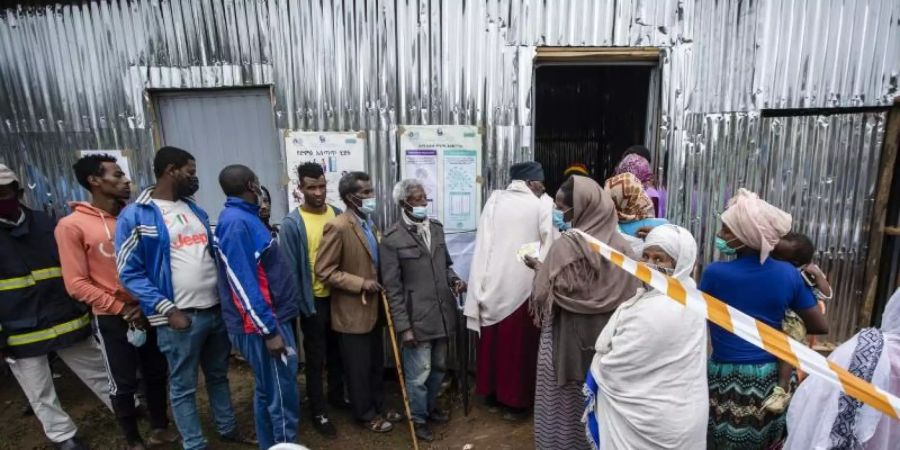 Menschen stehen vor einem Wahllokal in Addis Abeba Schlange. Foto: Ben Curtis/AP/dpa