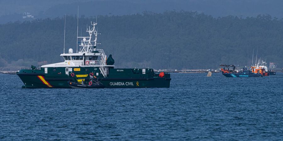 Schiffe der Guardia Civil und des Zolls beteiligen sich an der Bergung eines mutmasslichen Drogen-U-Boots, von dem nur eine Spitze aus dem Wasser ragt.