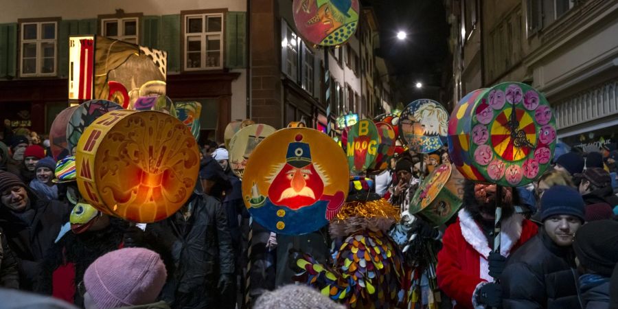 Fasnachtscliquen mit Laternen ziehen durch die Strassen am Morgestraich in Basel.