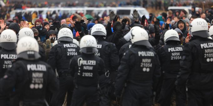 Polizisten und Demonstranten stehen sich bei der Demonstration von Klimaaktivisten am Rande des Braunkohletagebaus bei Lützerath gegenüber. Polizisten und Demonstranten stehen sich bei der Demonstration von Klimaaktivisten am Rande des Braunkohletagebaus bei Lützerath gegenüber.