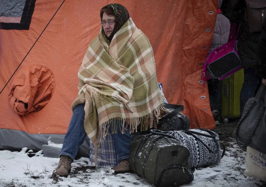 Eine Geflüchtete sitzt vor einem Zelt an der polnischen Grenze. Auch die Schweiz nimmt Menschen aus der Ukraine auf.