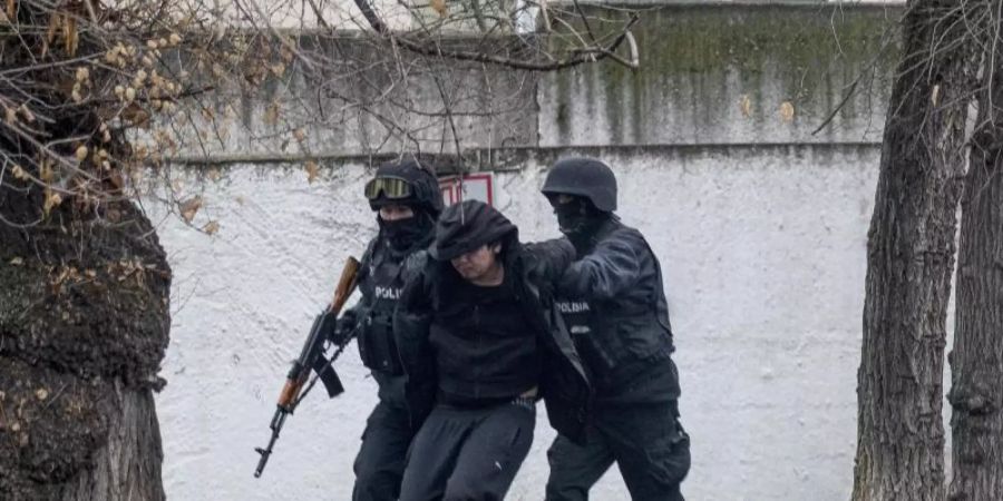 Schwer bewaffnete Polizisten nehmen einen Mann in Almaty fest, wo es erneut schwere Unruhen gegeben hat. Foto: Vasily Krestyaninov/AP/dpa