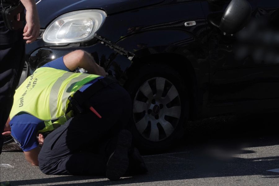 Ein Spezialist der Einsatzkräfte untersucht das beschädigte Auto.