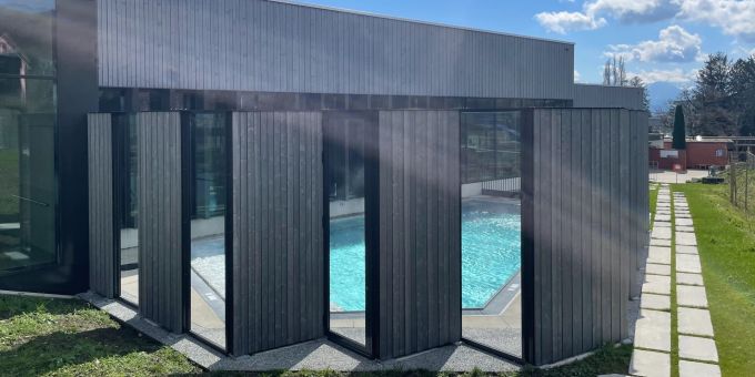 Die Lärmschutzwand passt sich gut in die Umgebung ein. Lärmschutzwand vor einem Aussenwasserbecken.