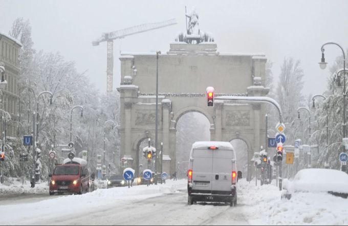 Der Verkehr rollt vorbei am verschneiten Siegestor. Schnee und Eis haben im Süden Bayerns auf den Strassen und bei der Bahn für Chaos gesorgt. Das Spiel der Bundesliga zwischen Bayern München und Union Berlin muss verschoben werden. bundesliga