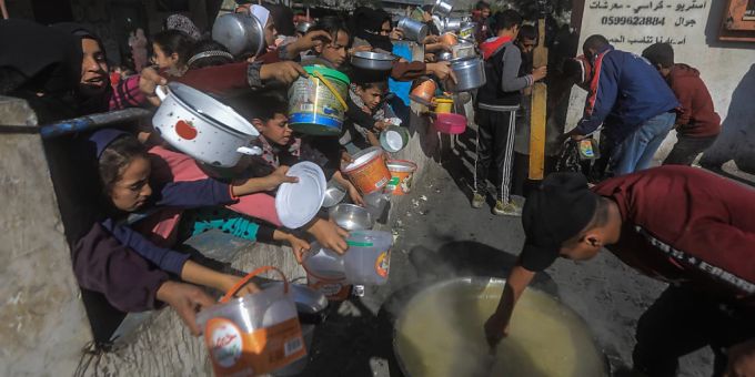Palästinenser versammeln sich mit Töpfen, um an einer von einer Wohltätigkeitsorganisation eingerichteten Spendenstelle Lebensmittel entgegenzunehmen. Foto: Mohammed Talatene/dpa Spendenstelle Gaza