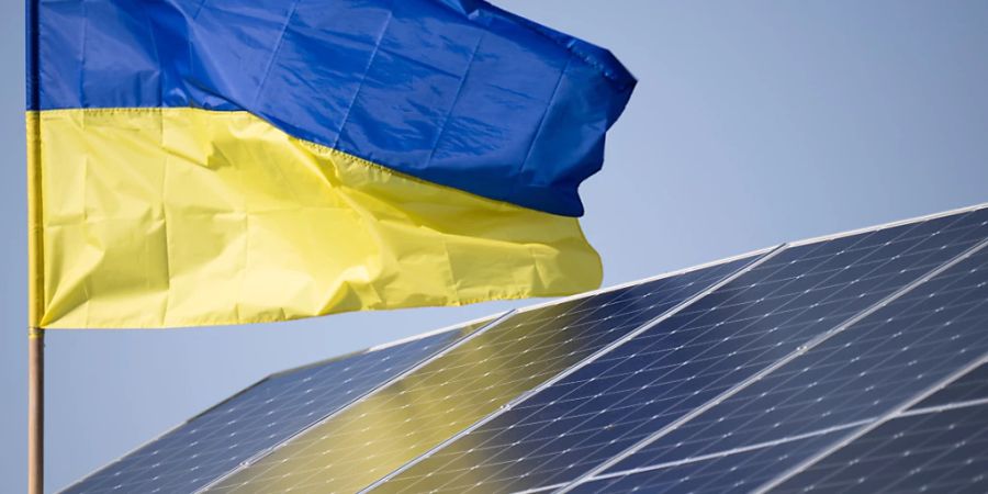 Eine Ukraine-Flagge weht über einer Solaranlage. Foto: Sebastian Gollnow/dpa