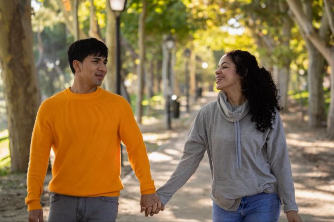 In lockerer Atmosphäre fällt es oft leichter, die Kommunikation mit dem Partner voranzutreiben. Pärchen beim Spaziergang im Park