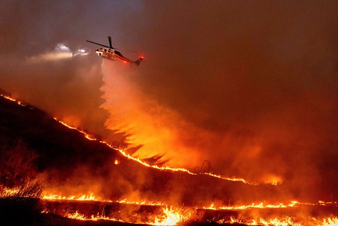 Flug durch das Inferno: Ein Hubschrauber wirft Wasser auf das Kenneth-Feuer in den West Hills von Los Angeles. Brände in Kalifornien