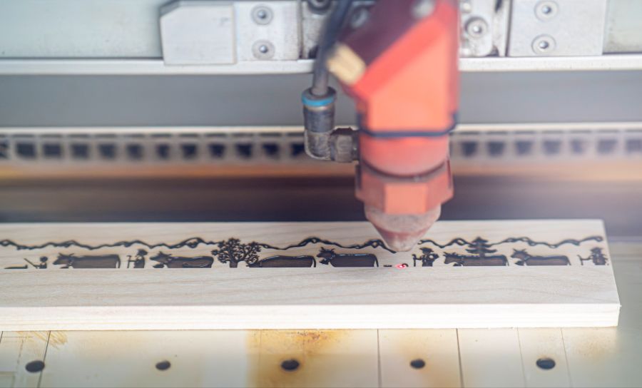 Mit einem Laserstrahl wird der Alpaufzug in das Holz gebrannt.